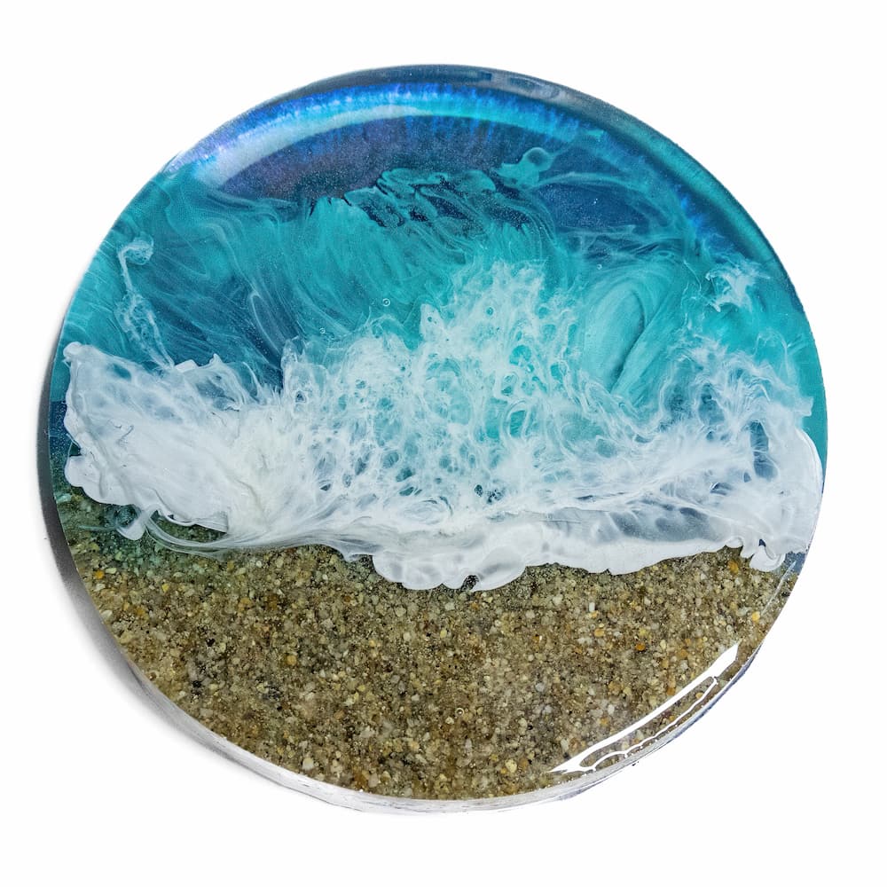 Sample of ocean themed resin coaster with sand and blue waves.