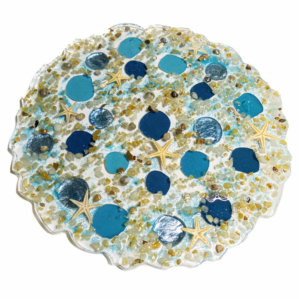 Flat resin decor piece with rocks, blue moasic stones, and starfish.